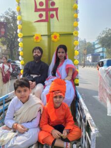 Group of children in traditional outfits reenacting scenes during Vivekananda Jayanti procession hosted by a yoga institute near Lake Gardens.