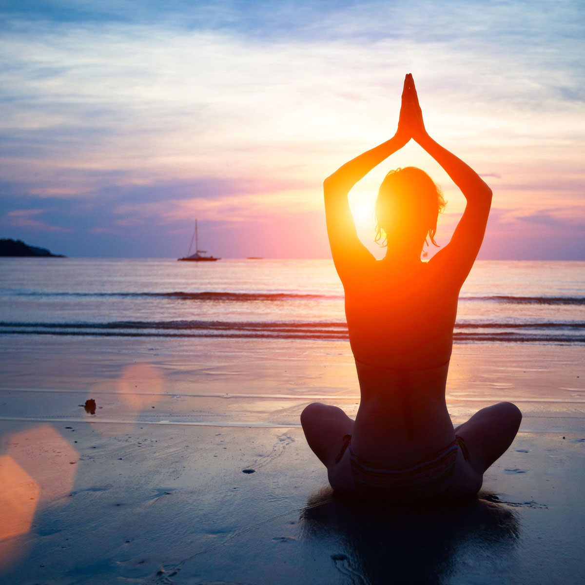 Person meditating in lotus pose during sunset on the beach, symbolizing peace and balance at a yoga centre in Kolkata.