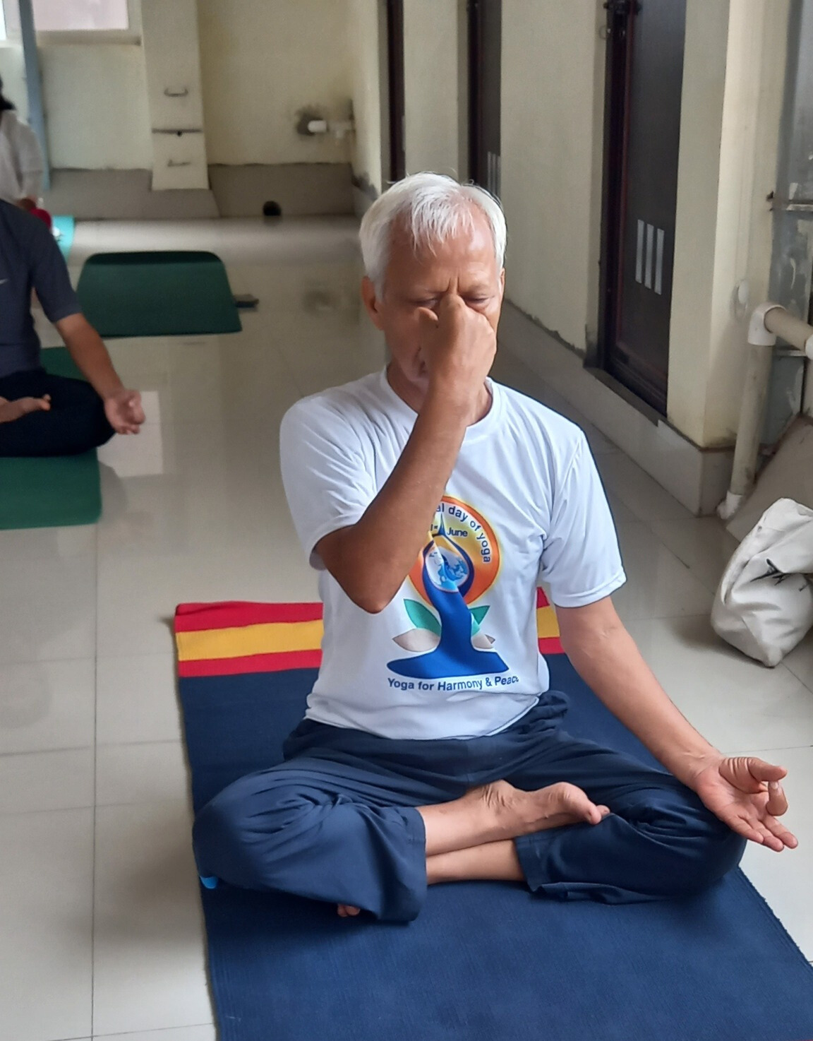 Elderly man practicing pranayama breathing exercise in yoga classes near you.