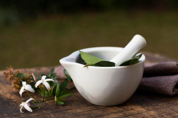 Natural herbal bowl and leaves symbolizing holistic healing at a naturopathy center in Kolkata